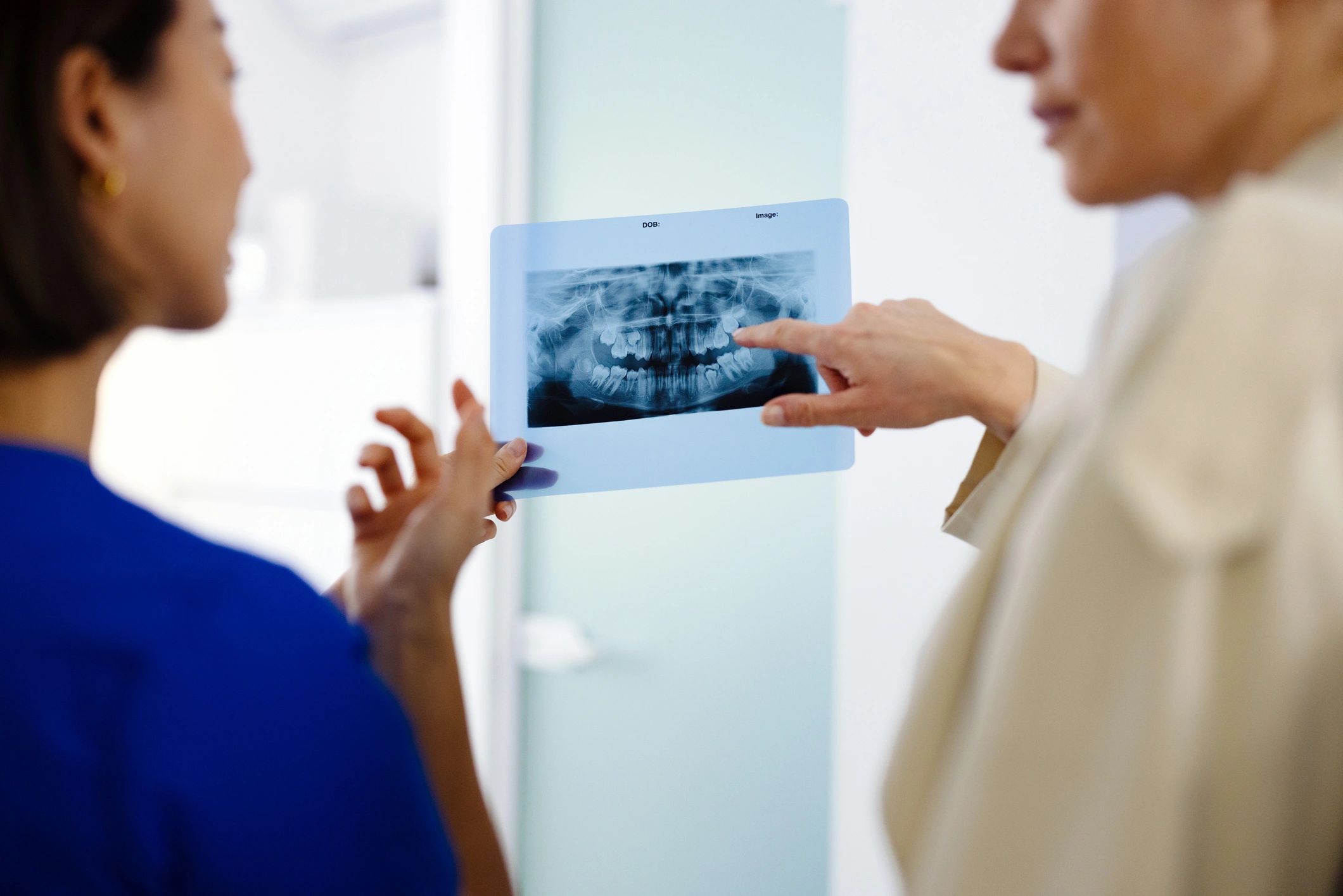 Dentist reviewing a dental x-ray with a patient in a bright clinic